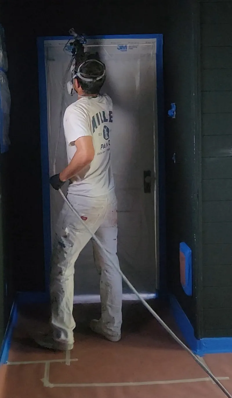 Myles spraying paint on a project